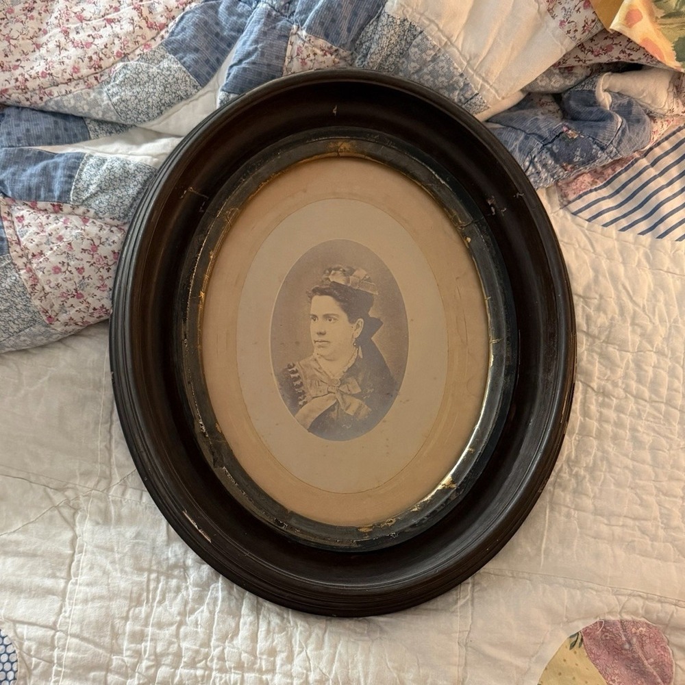 Victorian-era antique oval black wood picture frame woman